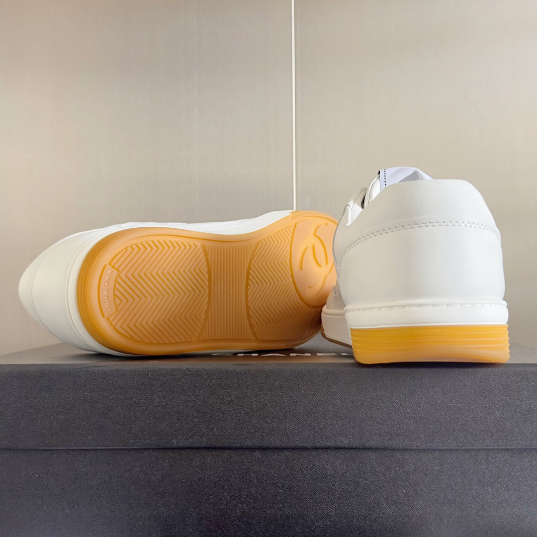 White low-top sneaker heel and outsole view with gum yellow rubber sole