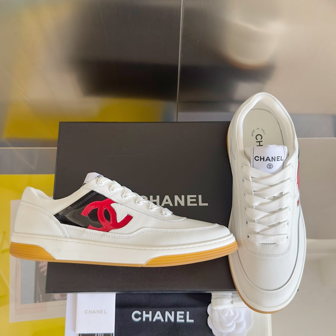 White low-top sneakers with red CC logo on side and lace-up front, gum sole