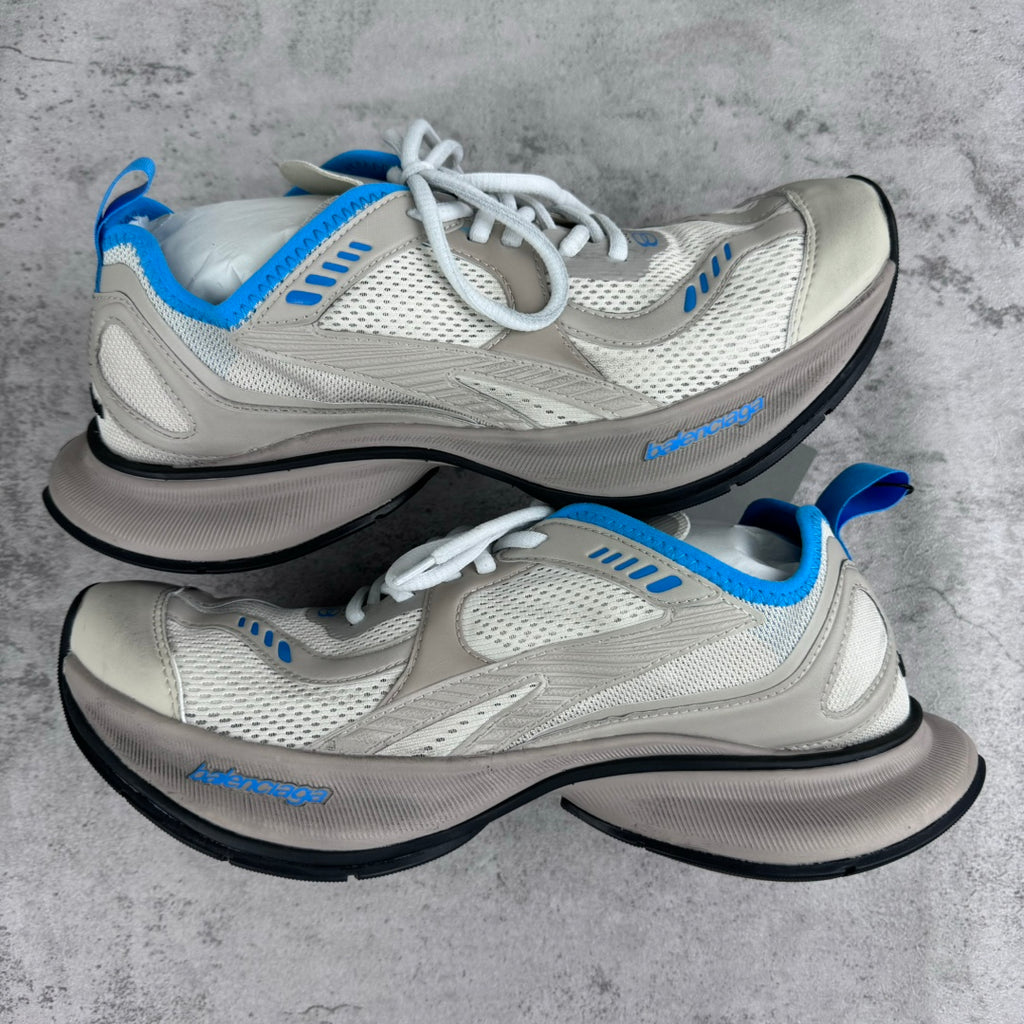 White and blue lace-up sneakers with mesh panels and thick black sole.