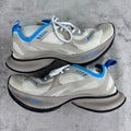White and blue lace-up sneakers with mesh panels and thick black sole.