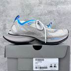 White lace-up sneakers with blue accents, mesh upper, and thick black sole.