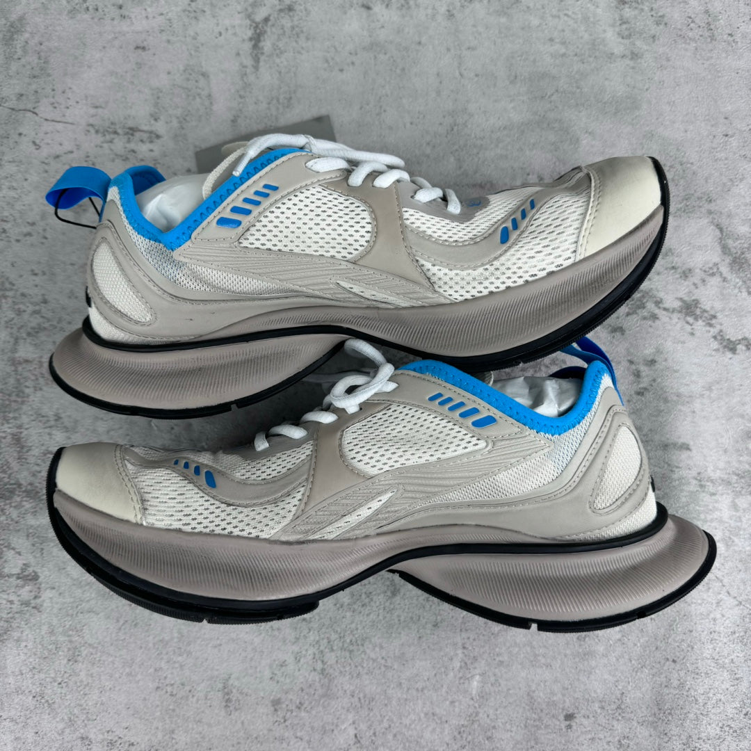 White lace-up sneakers with blue accents, mesh upper, and chunky black sole pair.