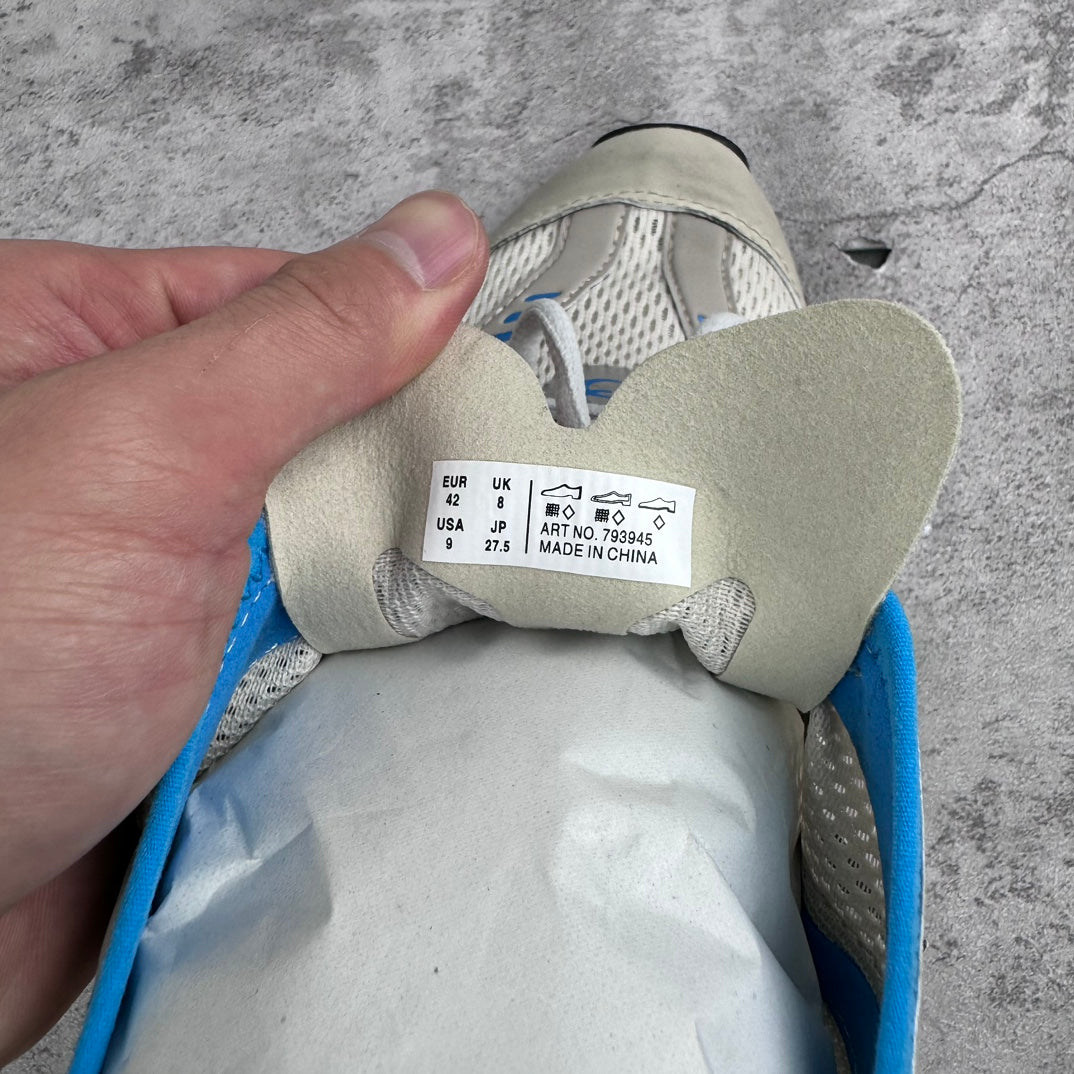 Sneaker interior with size label and blue collar trim, viewed from the heel.