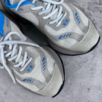 White and blue lace-up sneakers with mesh uppers and cushioned midsole.