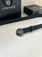 Dark leather belt with round silver-toned Medusa buckle and adjustable holes
