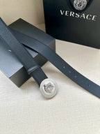 Dark leather belt with long strap and round silver Medusa buckle
