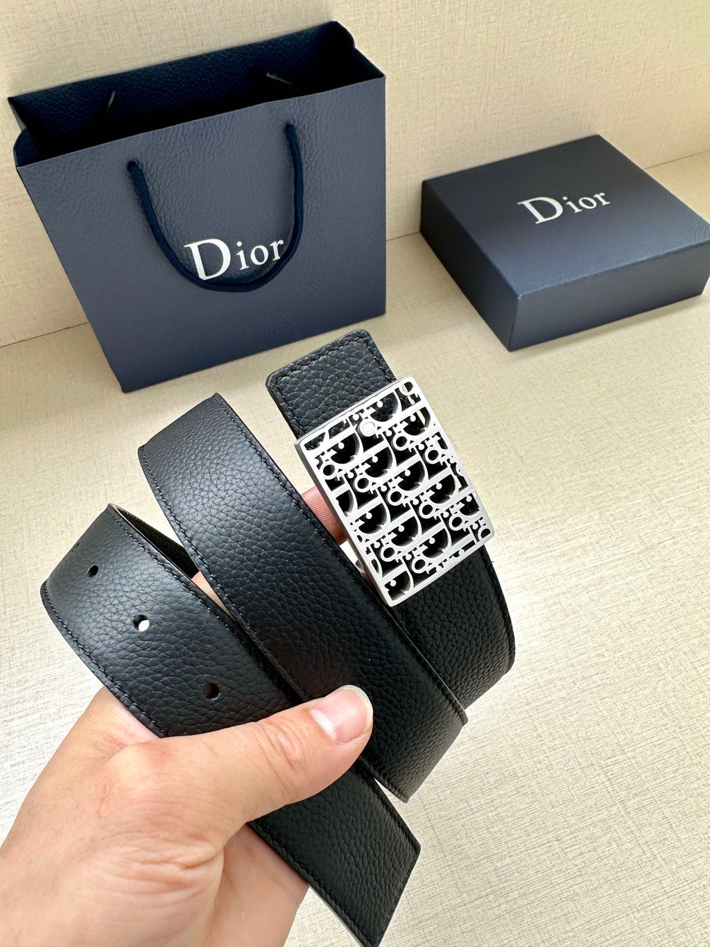 Dior leather belt with square monogram buckle; belt end with punched holes.