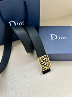Dior leather belt with textured strap and gold-toned monogram buckle.