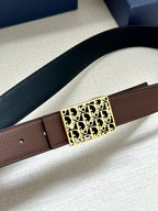Reversible leather belt close-up: textured black strap, gold Dior-pattern buckle, brown underside.