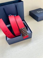 Dior belt set in red leather with dark strap and patterned buckle.