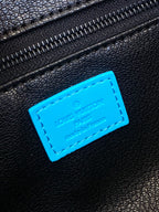 Louis Vuitton leather logo patch on black bag with bright blue stitched label