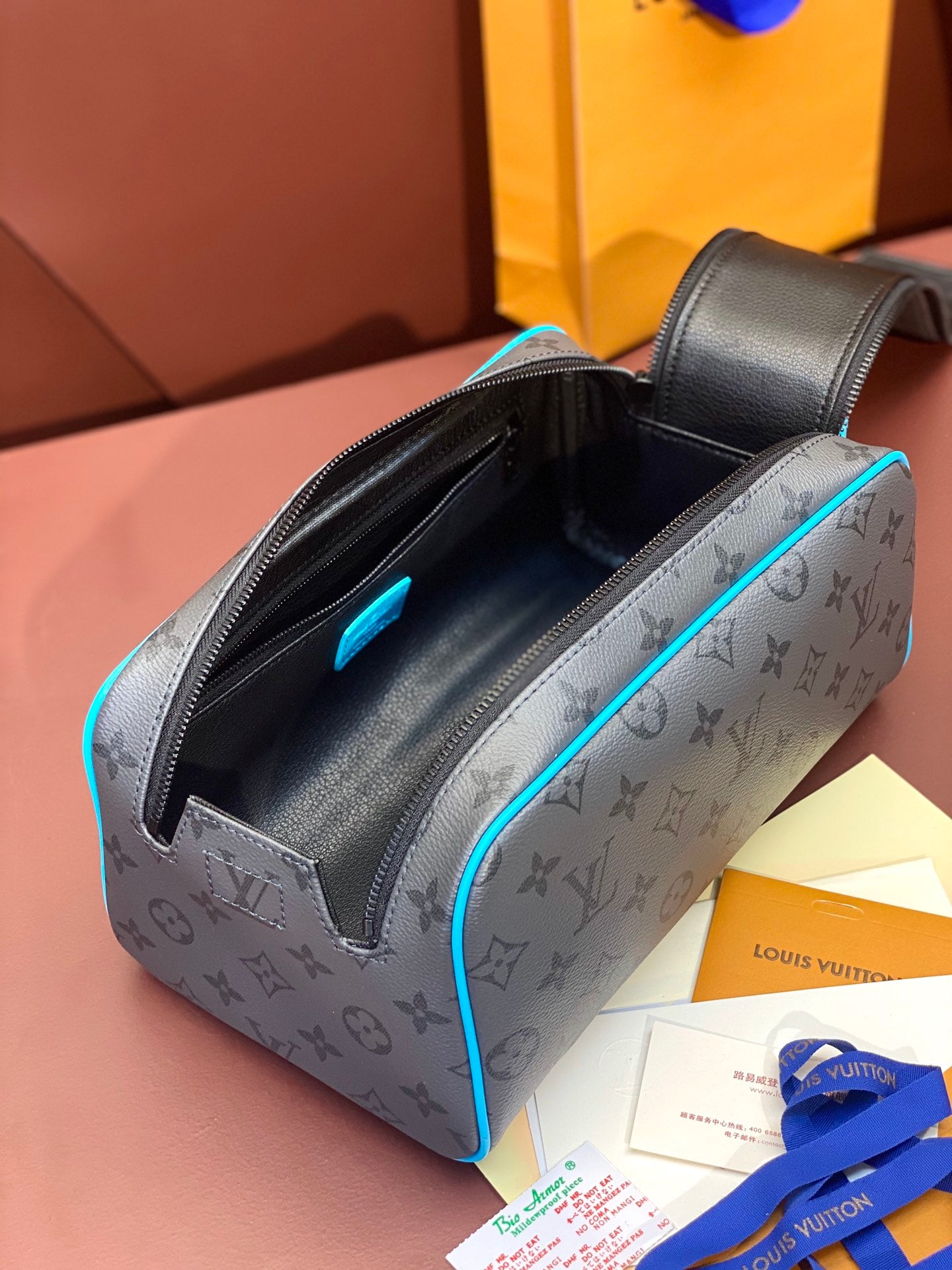 Louis Vuitton toiletry bag with monogram print, open zipper, blue-trimmed handle