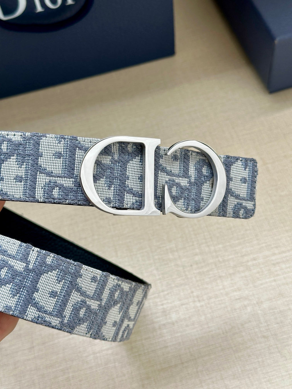 Dior belt detail with silver CD buckle on light-blue logo strap