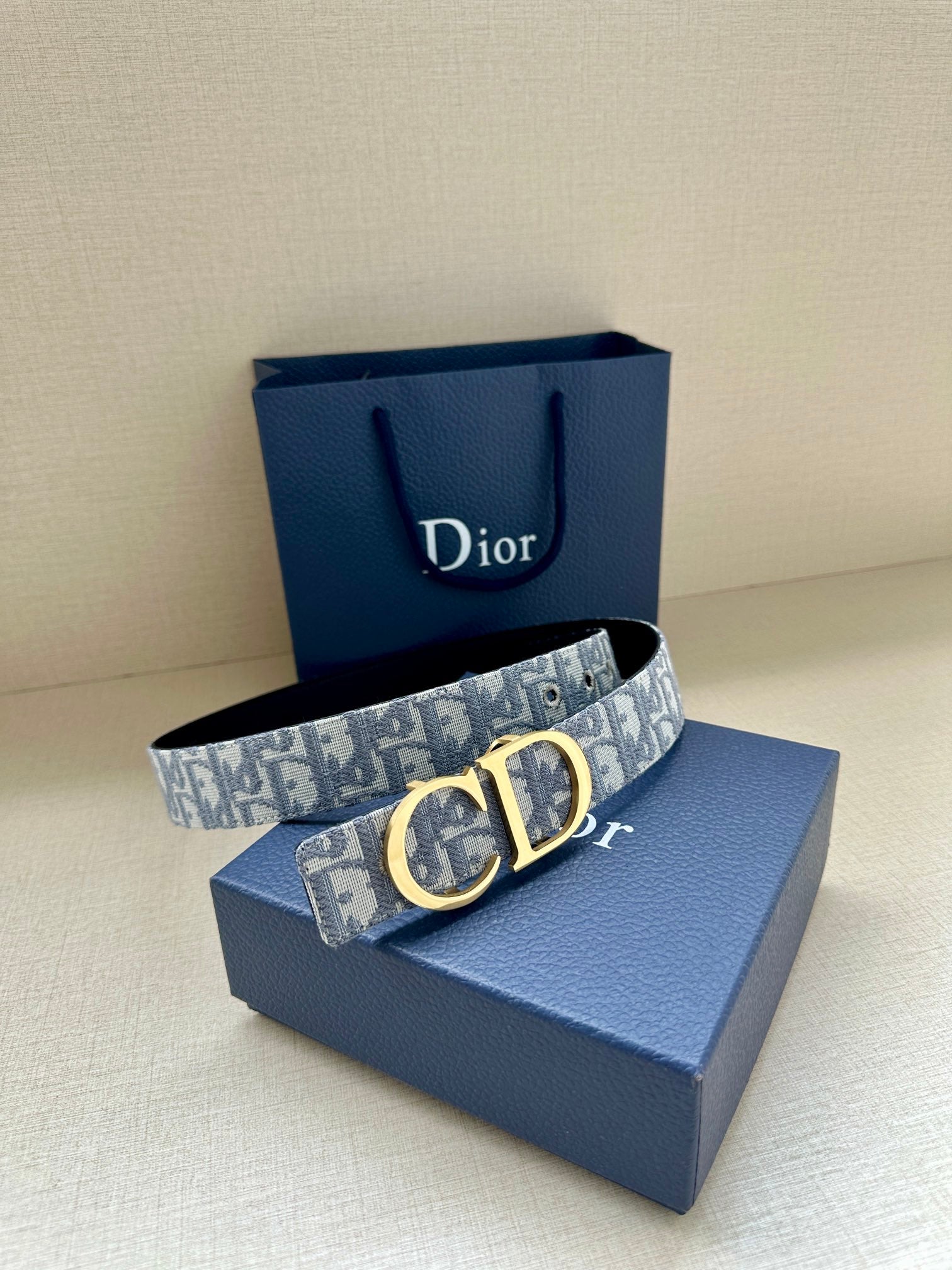 Dior belt with gold CD buckle on light-blue logo strap