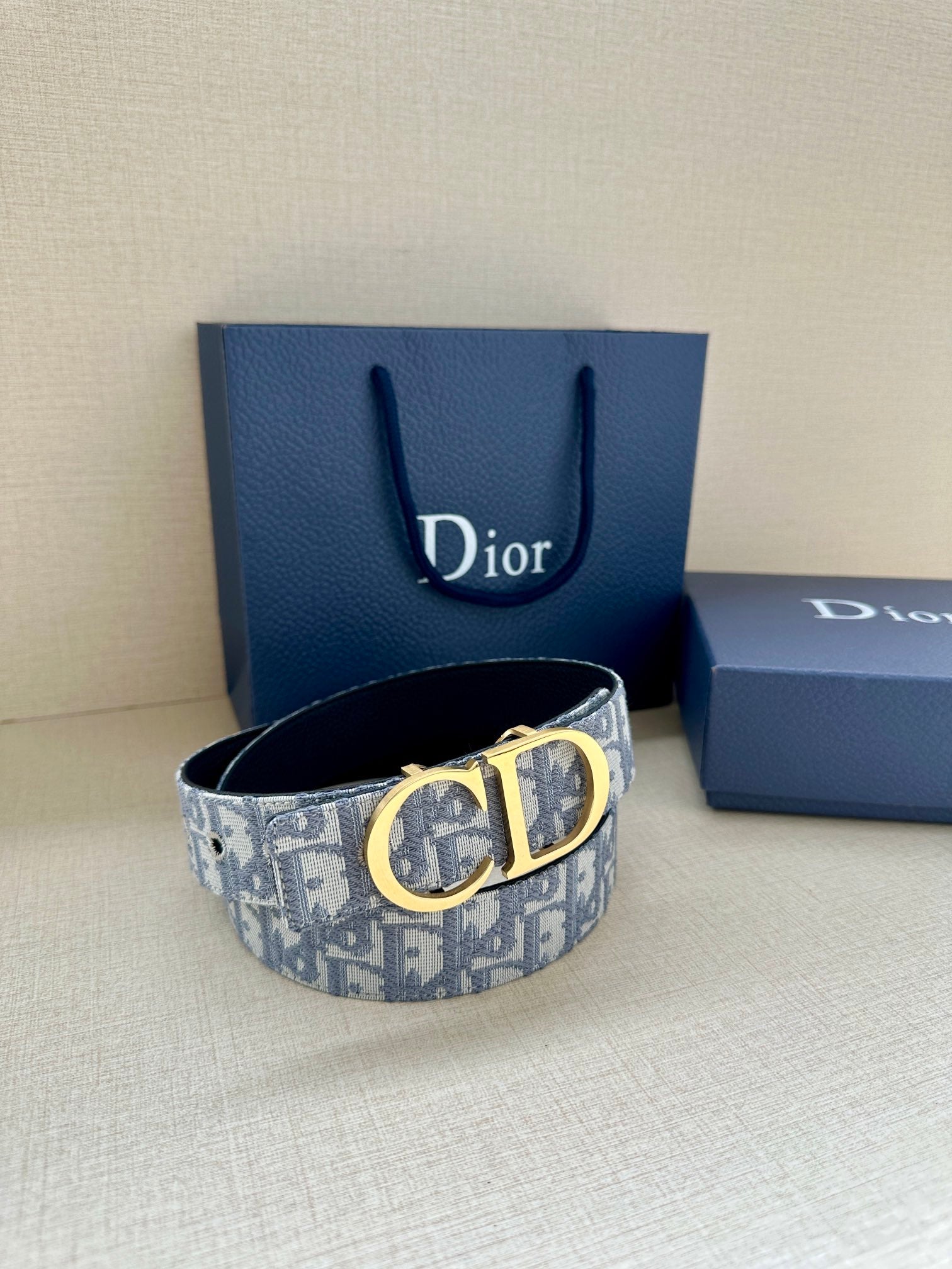 Dior belt with gold CD buckle on light-blue logo strap