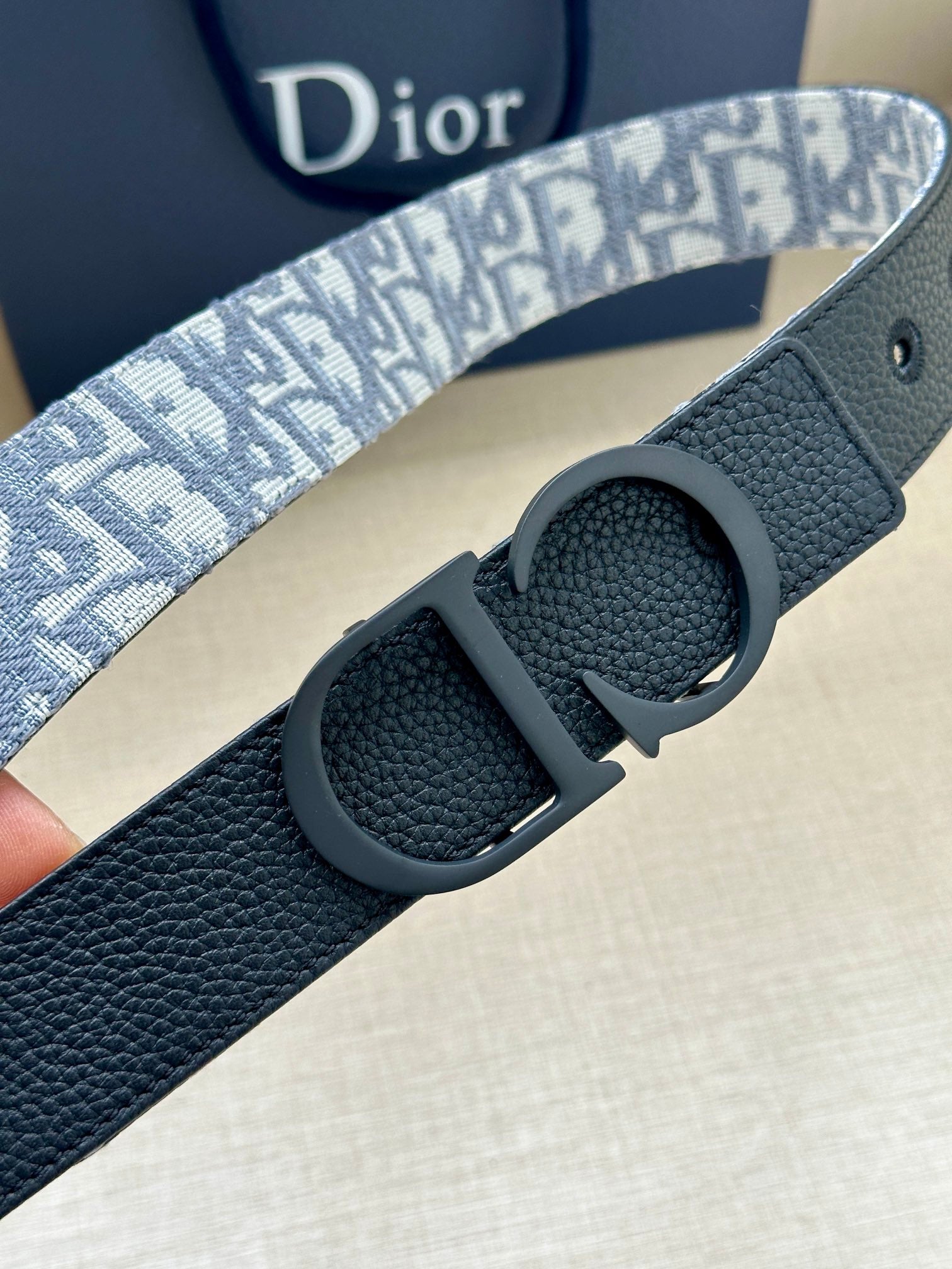 Leather Dior belt with blue patterned strap and round dark buckle detail