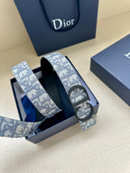 Dior belt with blue patterned strap and dark buckle, coiled in packaging
