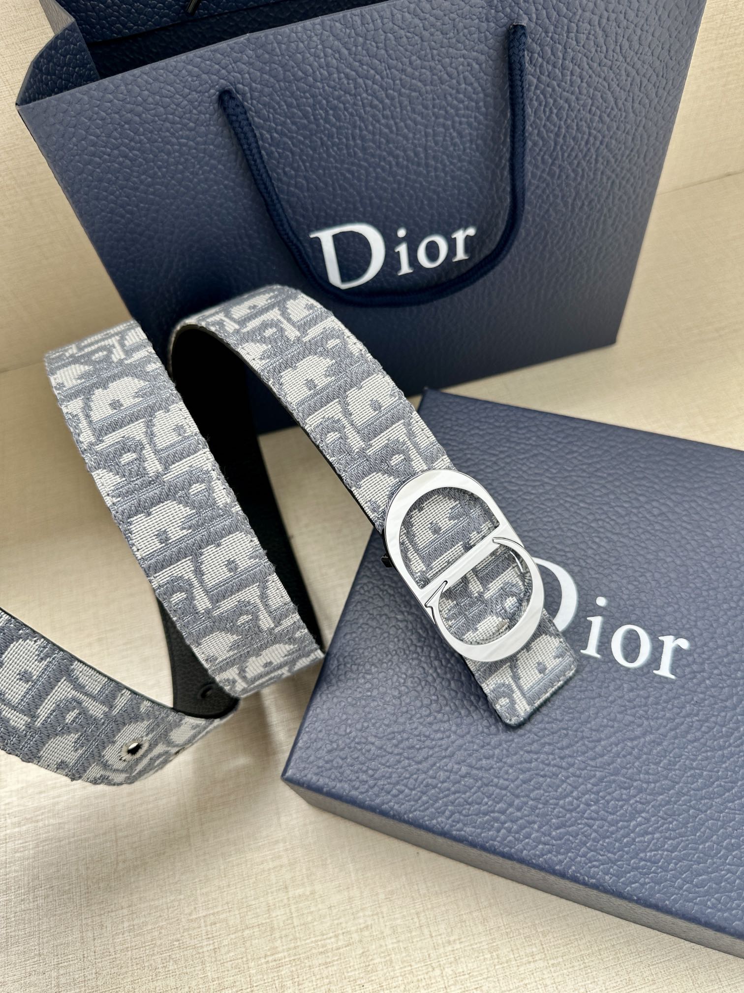 Dior belt with light blue-gray monogram strap and silver round buckle