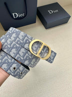 Dior belt close-up with light blue monogram strap and gold-tone oval buckle