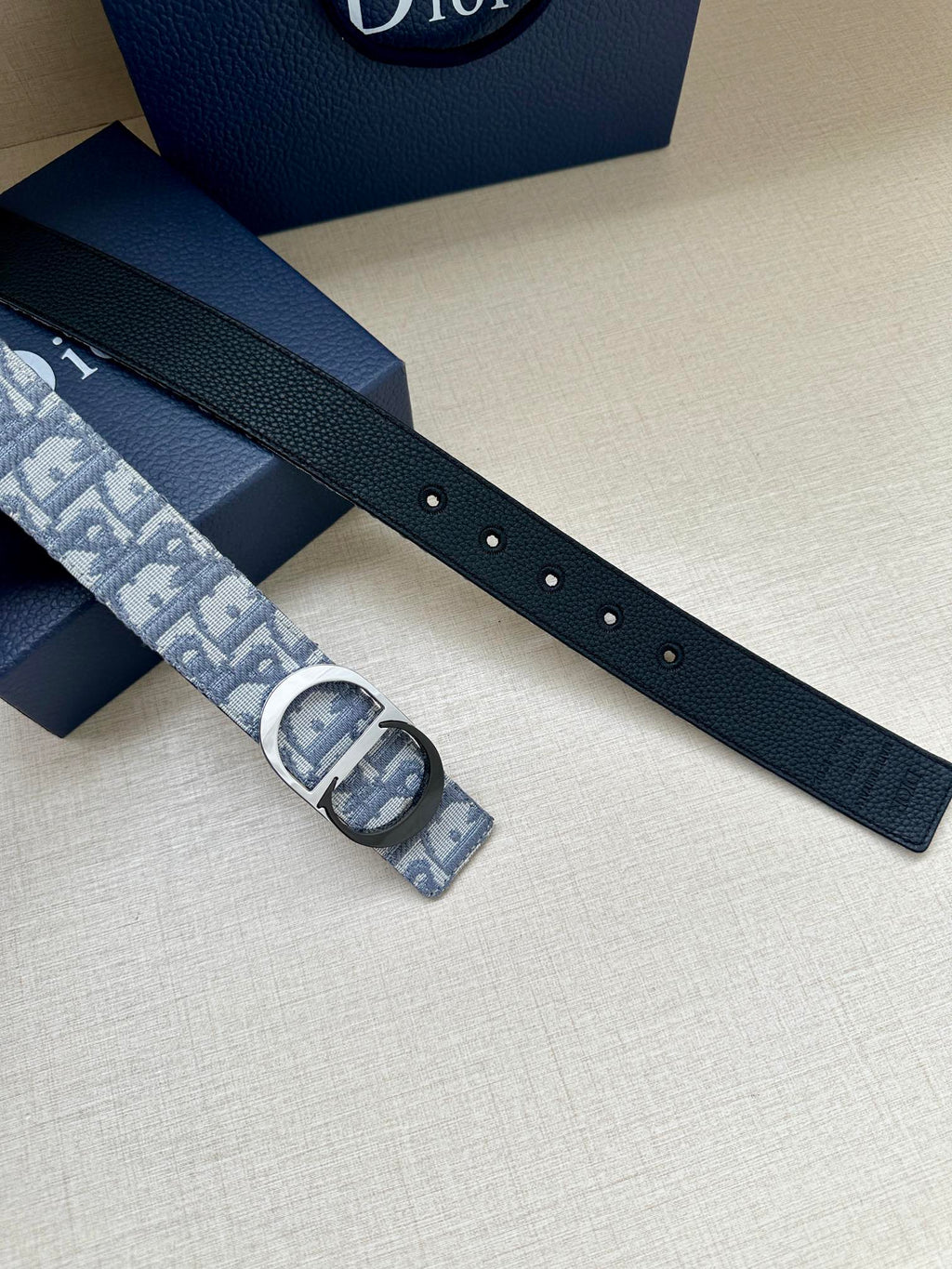 Dark leather belt strap with holes and jacquard buckle keeper