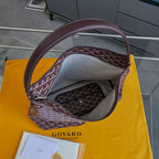Burgundy patterned Goyard tote bag interior with zipper pocket and top handle.