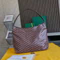 Burgundy patterned Goyard tote bag with top handles and green lining visible.