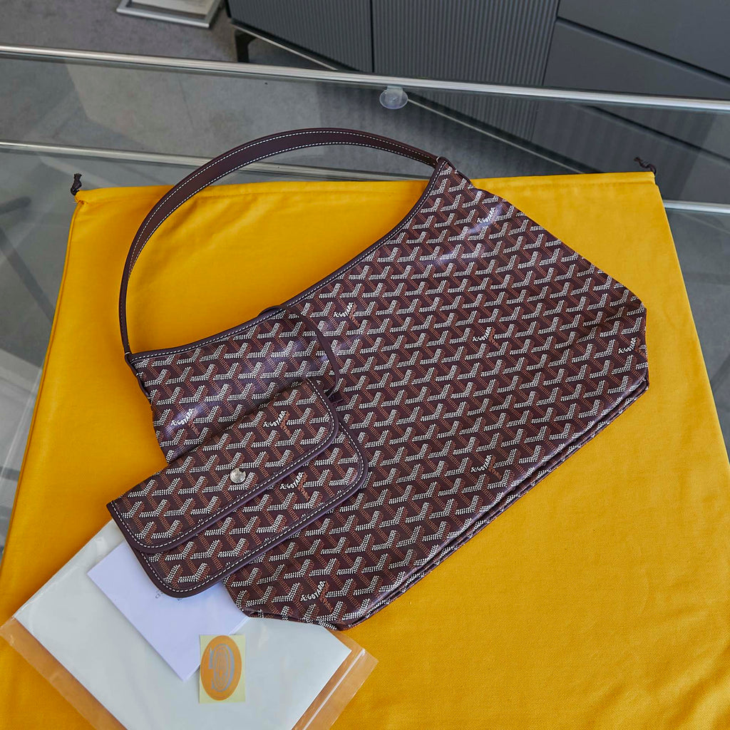 Burgundy patterned Goyard hobo bag with curved handle and open top.