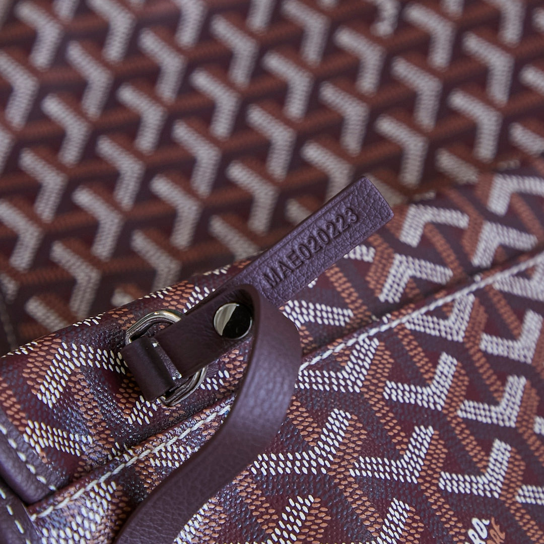 Burgundy Goyard patterned clasp and strap detail on mini pouch.