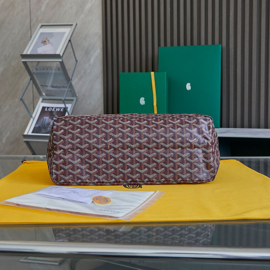Burgundy patterned Goyard tote bag with wide base and top zipper closure.