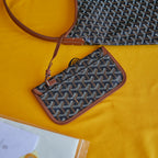 Monogram canvas crossbody pouch with brown leather trim and zip closure
