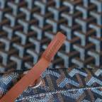 Brown leather pull tab on monogram canvas bag near the top seam