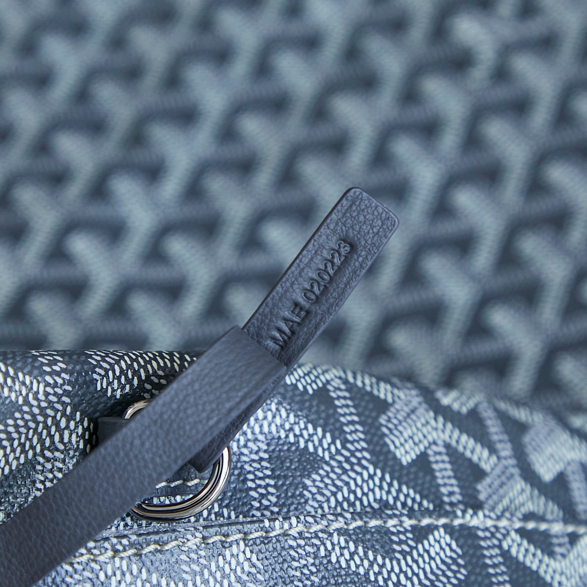 Goyard strap with embossed leather tab and metal ring