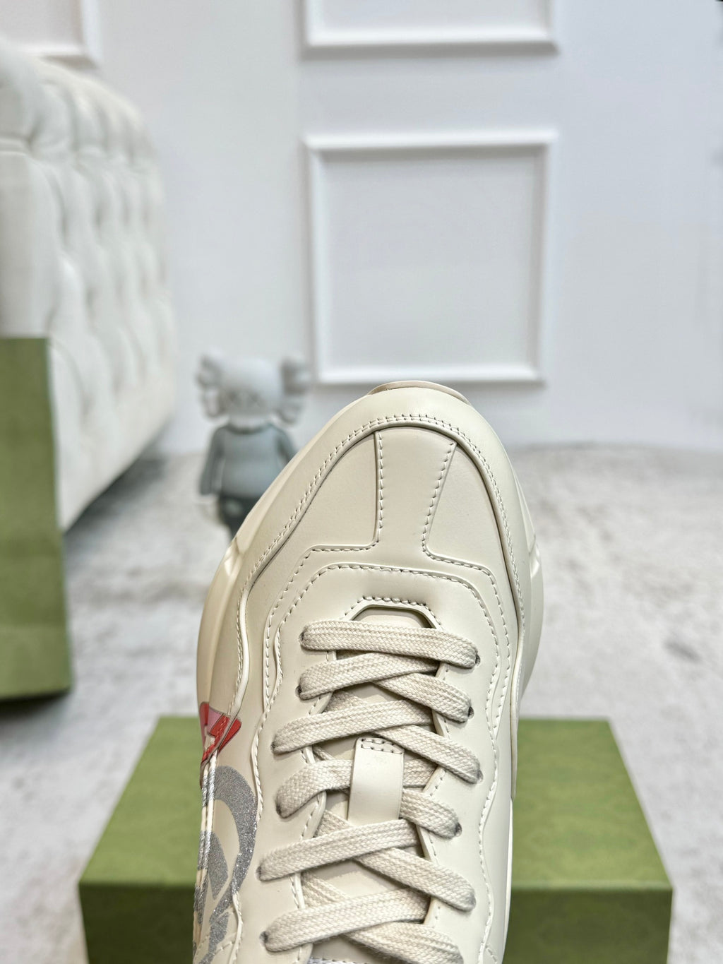 Gucci unisex off-white sneaker close-up, lace-up front and stitched toe cap