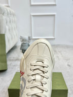 Gucci unisex off-white sneaker close-up, lace-up front and stitched toe cap