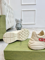 Cream Gucci unisex sneakers with textured tread outsole and rear logo detail.