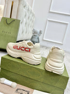 Cream Gucci unisex lace-up sneakers with red GUCCI logo, rear and side view.