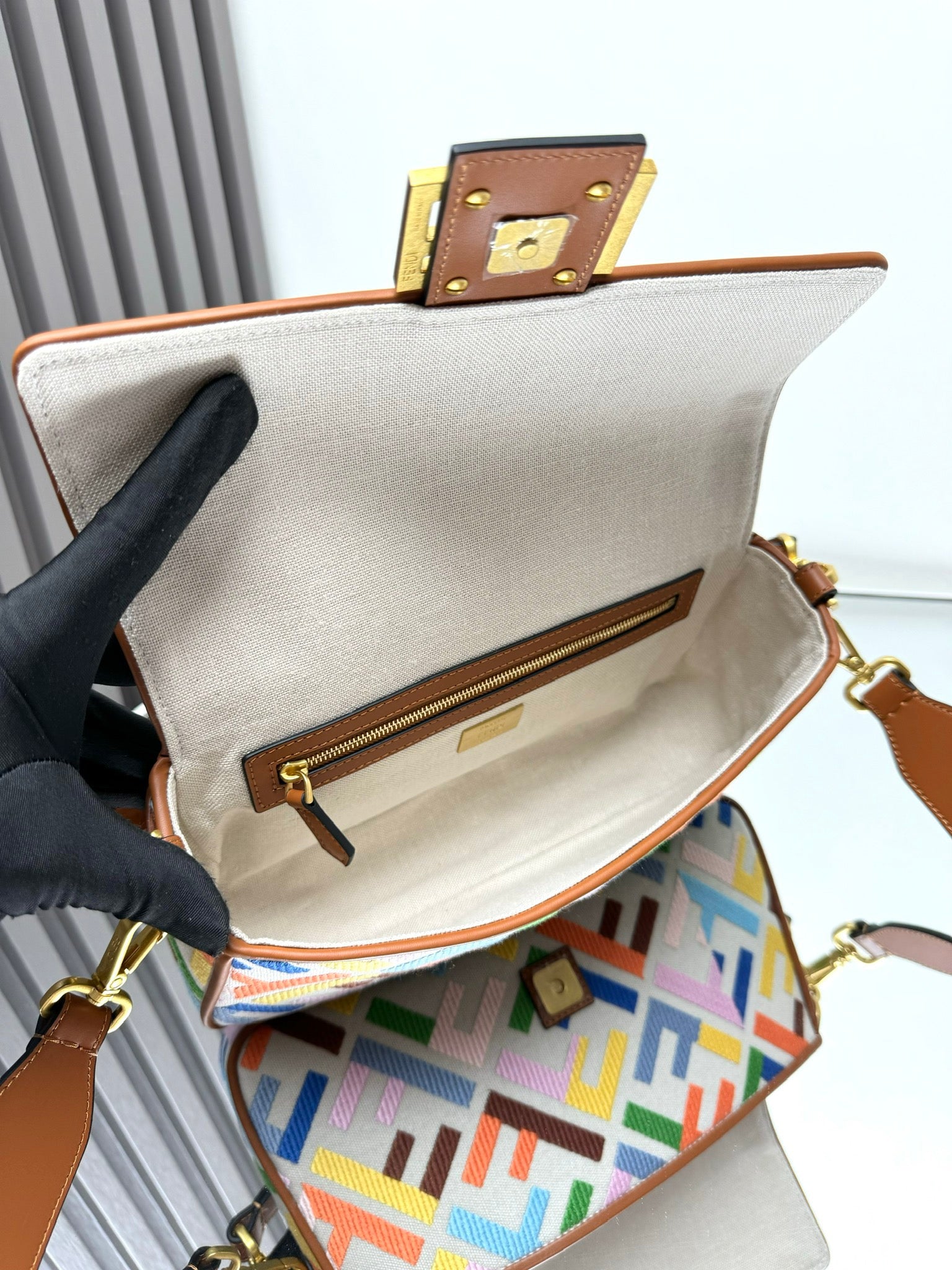 Baguette shoulder bag open top with cream lining, gold zipper and logo plate