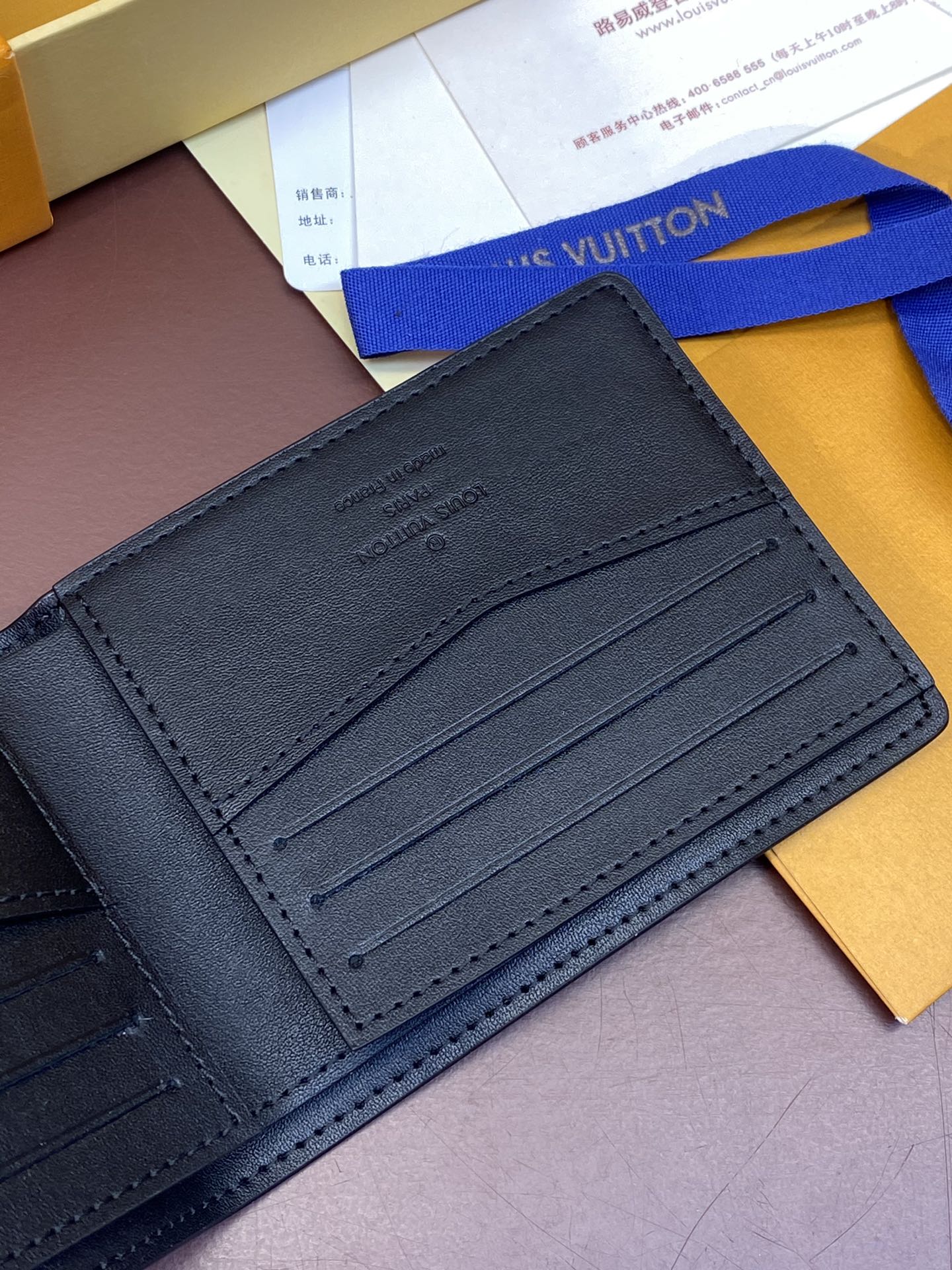 Small leather wallet with embossed logo on card slot panel, stitched borders