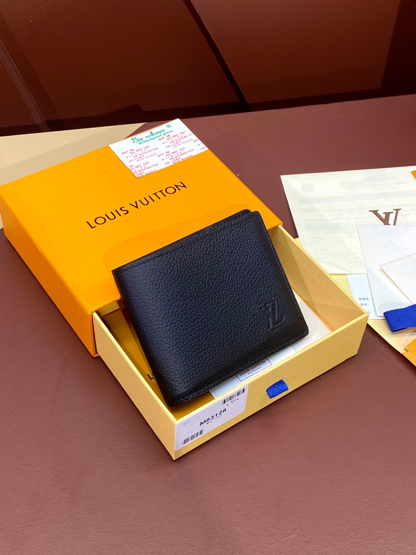 Small leather wallet with embossed logo, folded design, dark navy color