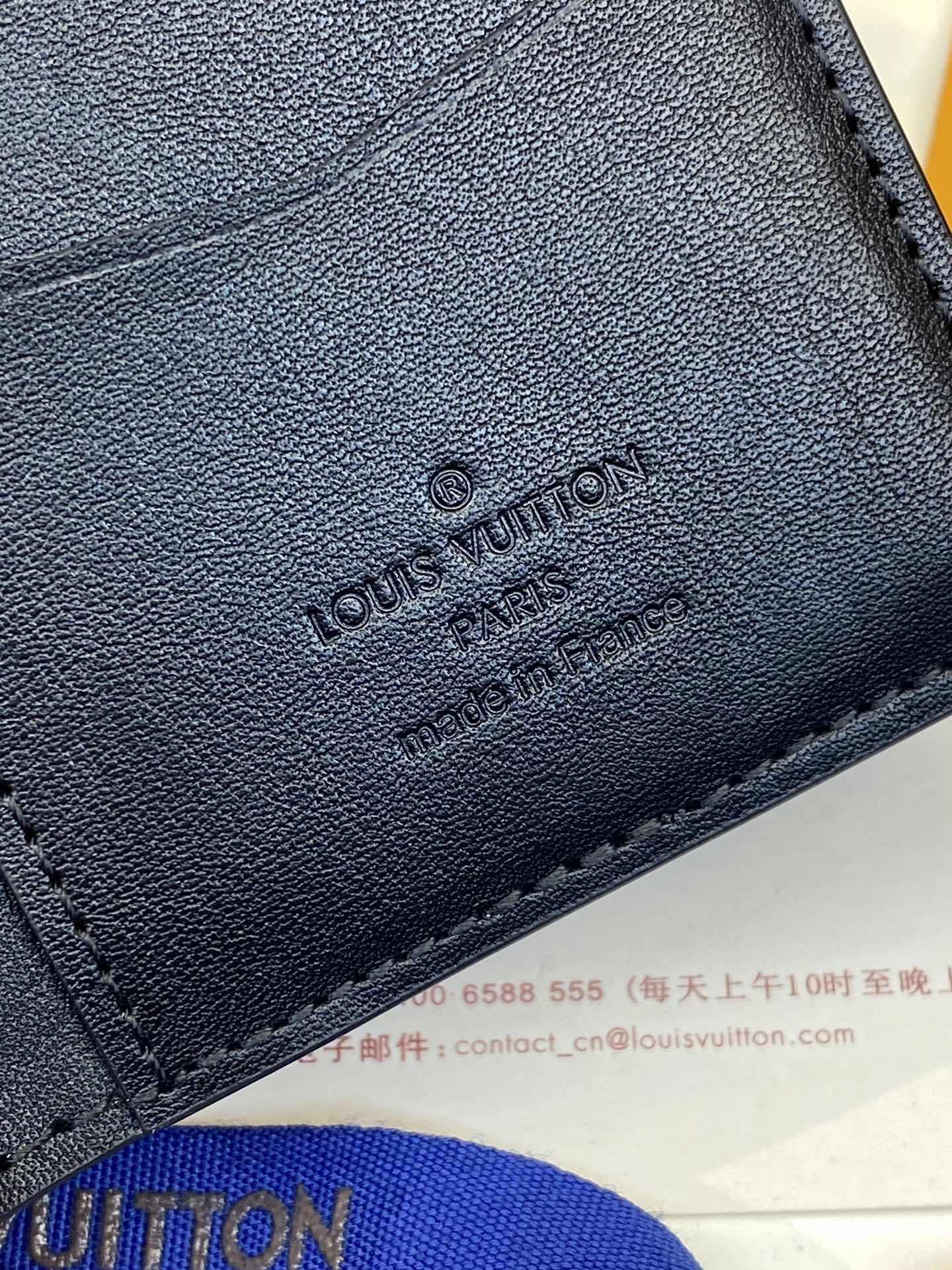Dark blue leather wallet with embossed Louis Vuitton logo on front