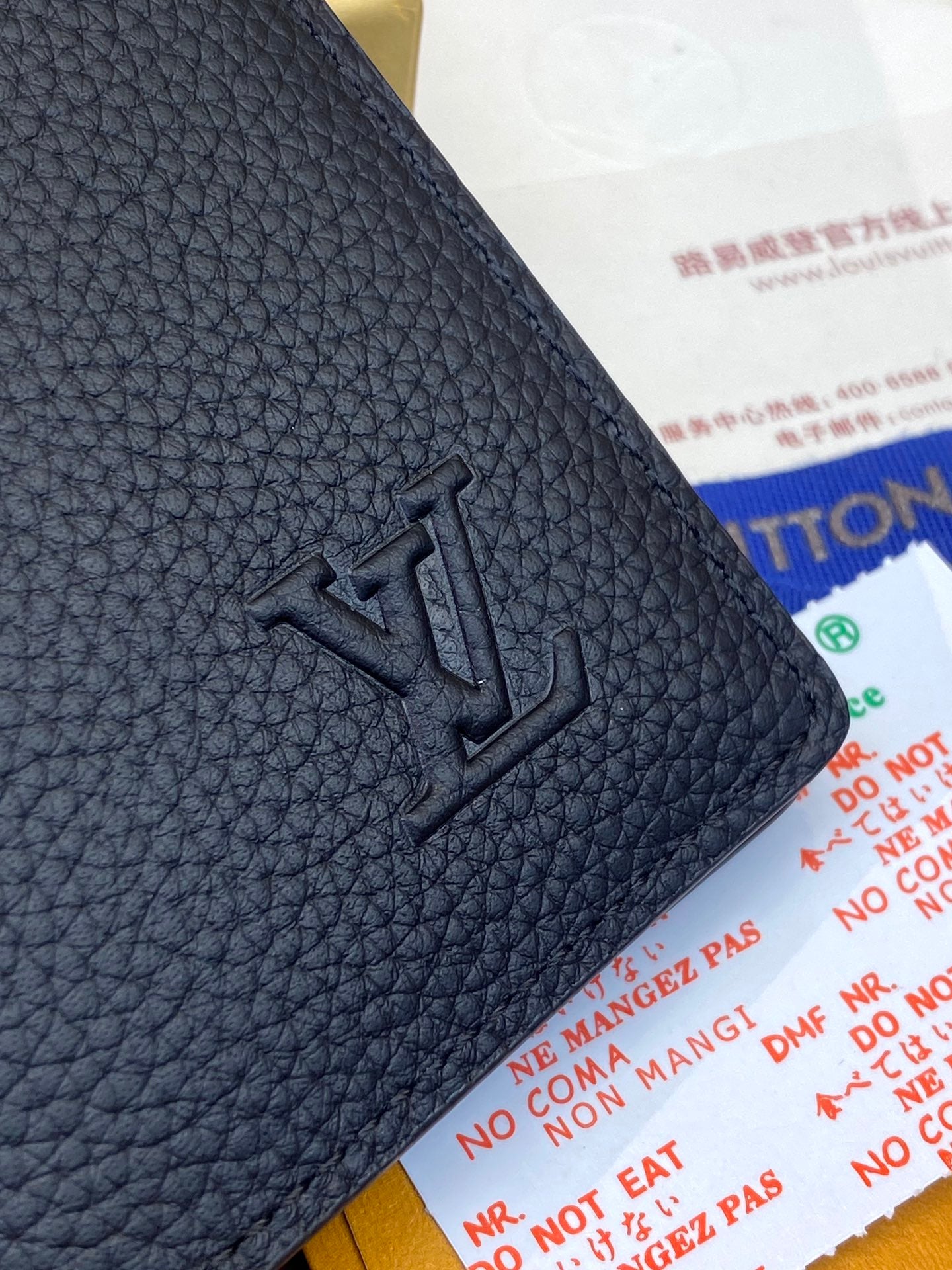 Dark blue leather wallet corner with embossed LV logo detail