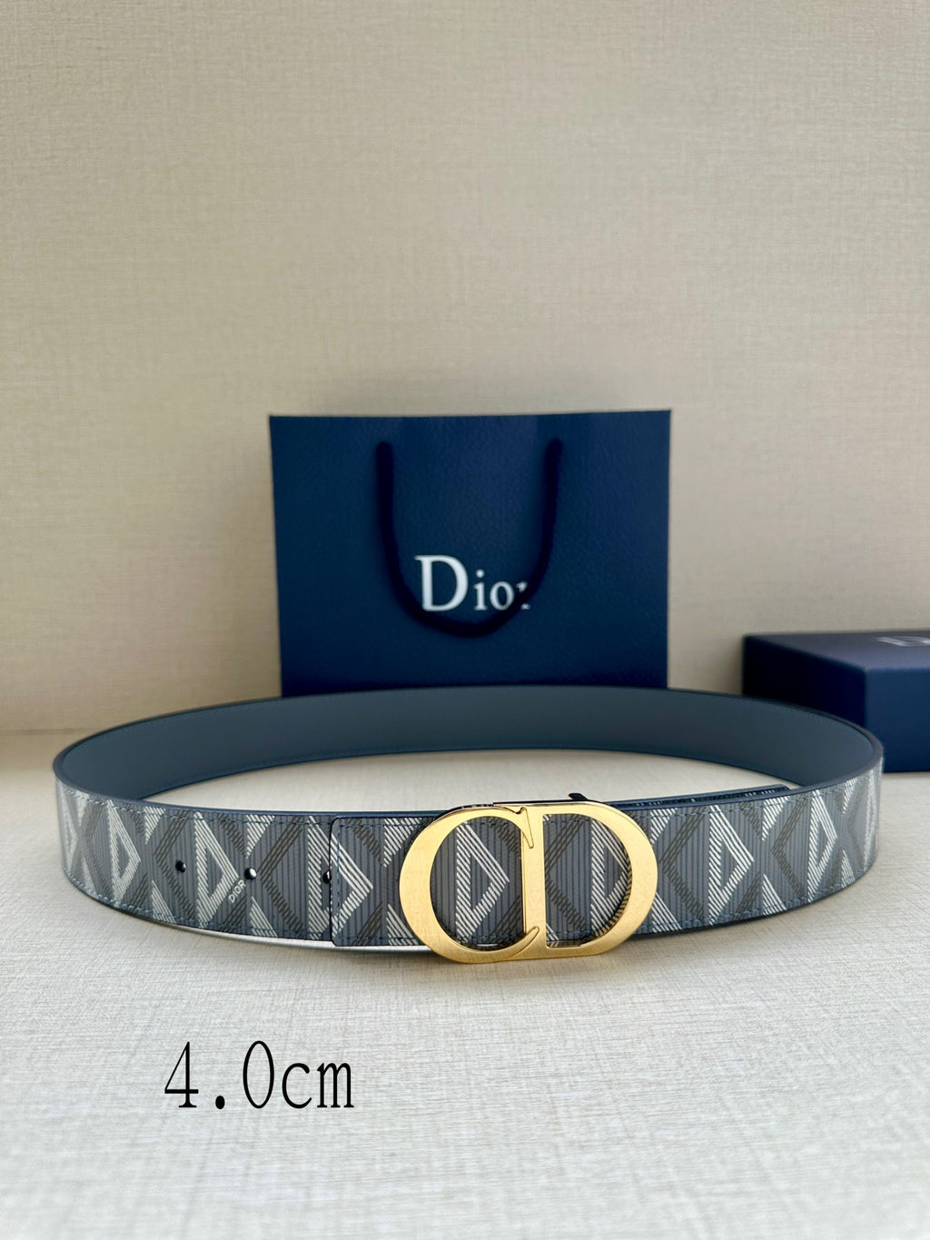 Designer belt by Dior: gray-blue monogram strap with gold CD buckle.