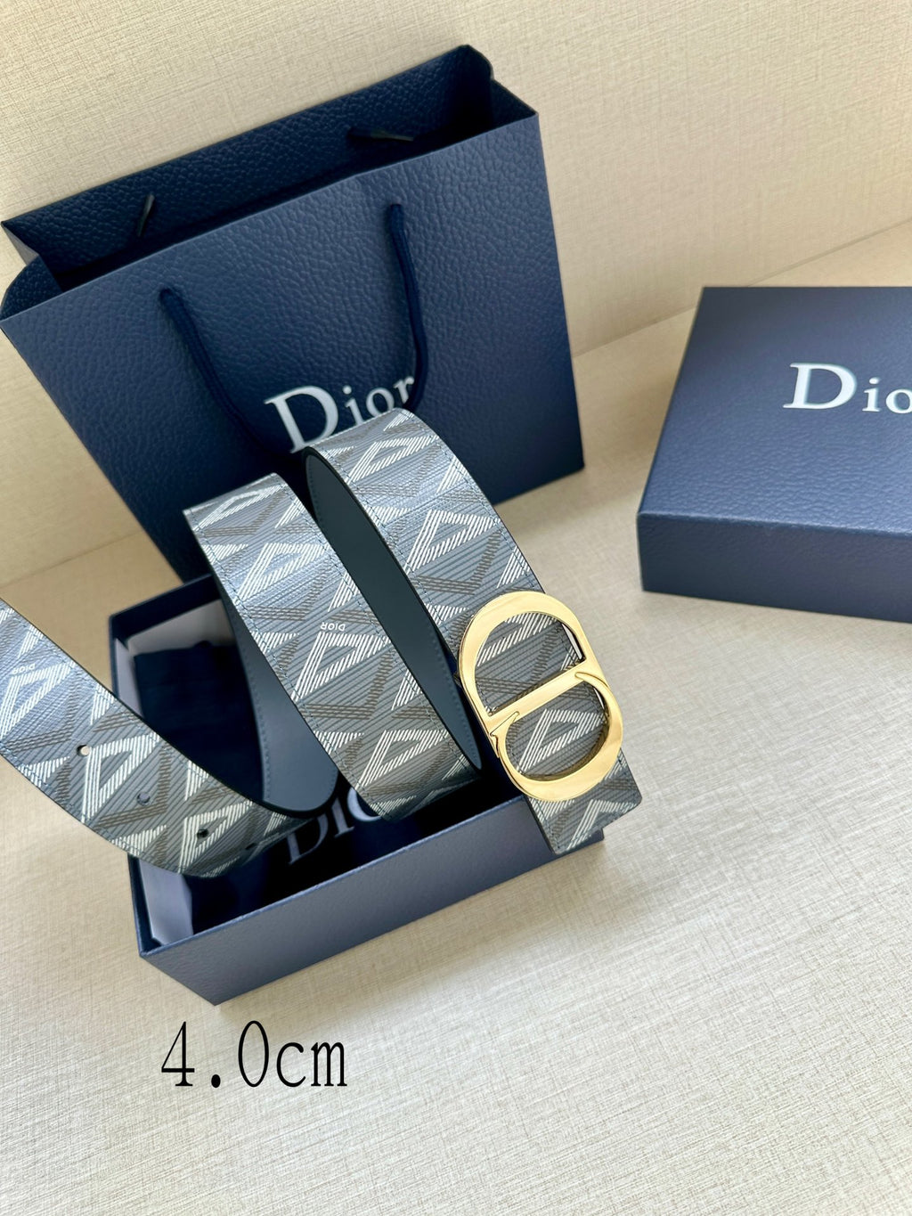 Designer belt by Dior in gray-blue monogram canvas with gold CD buckle, close angle.