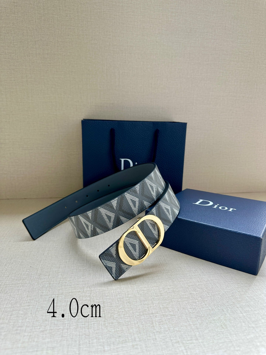 Designer belt by Dior with gray-blue monogram strap and gold CD buckle, angled.