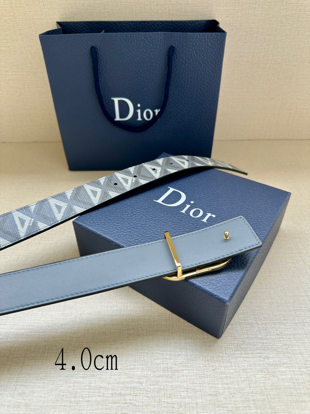 Designer belt by Dior, gray-blue monogram strap with gold CD buckle and keeper.