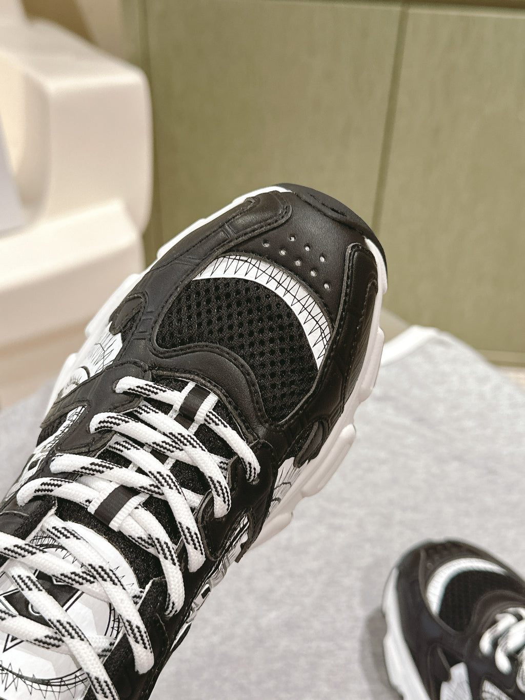 Unisex sneaker toe detail in black with perforated upper and white panels