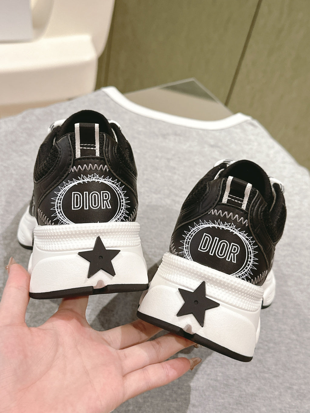 Unisex sneakers heel view with Dior logo, black and white star detail