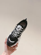 Unisex sneaker with black upper, white laces, and chunky white sole