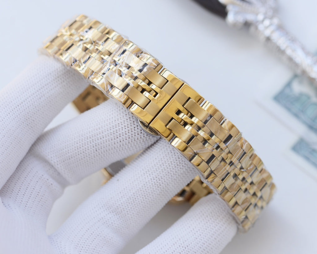 Two-tone Rolex wristwatch side view with diamond bezel and braided metal link bracelet