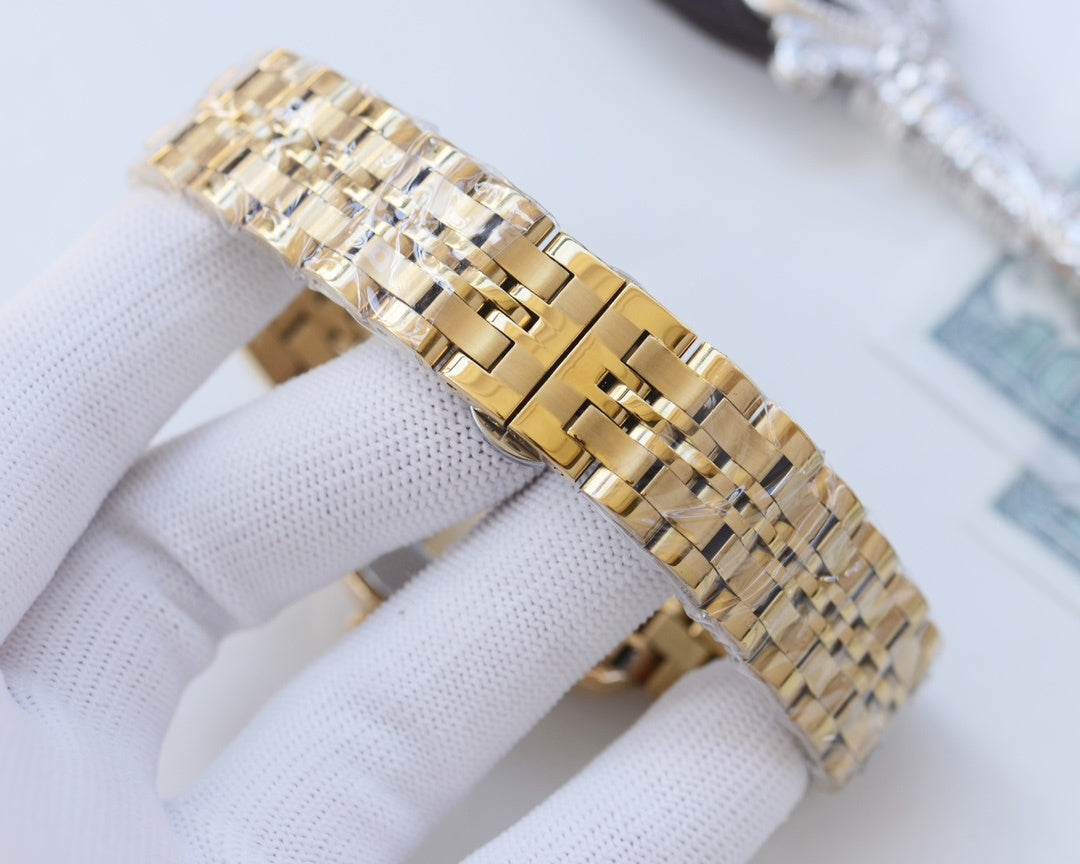 Two-tone Rolex wristwatch side view with diamond bezel and braided metal link bracelet